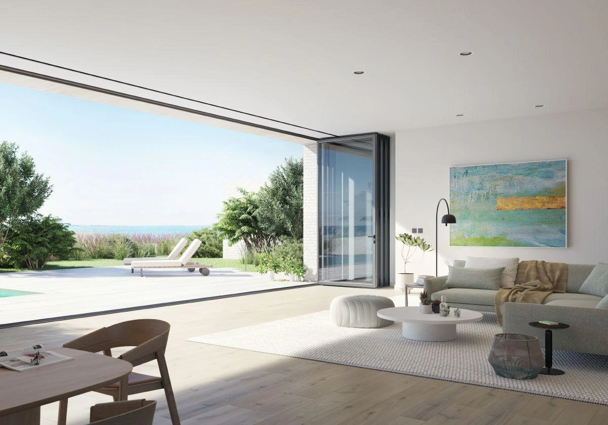 Geöffnete Schüco Falttüren verbinden einen Wohnraum mit der Terrasse
