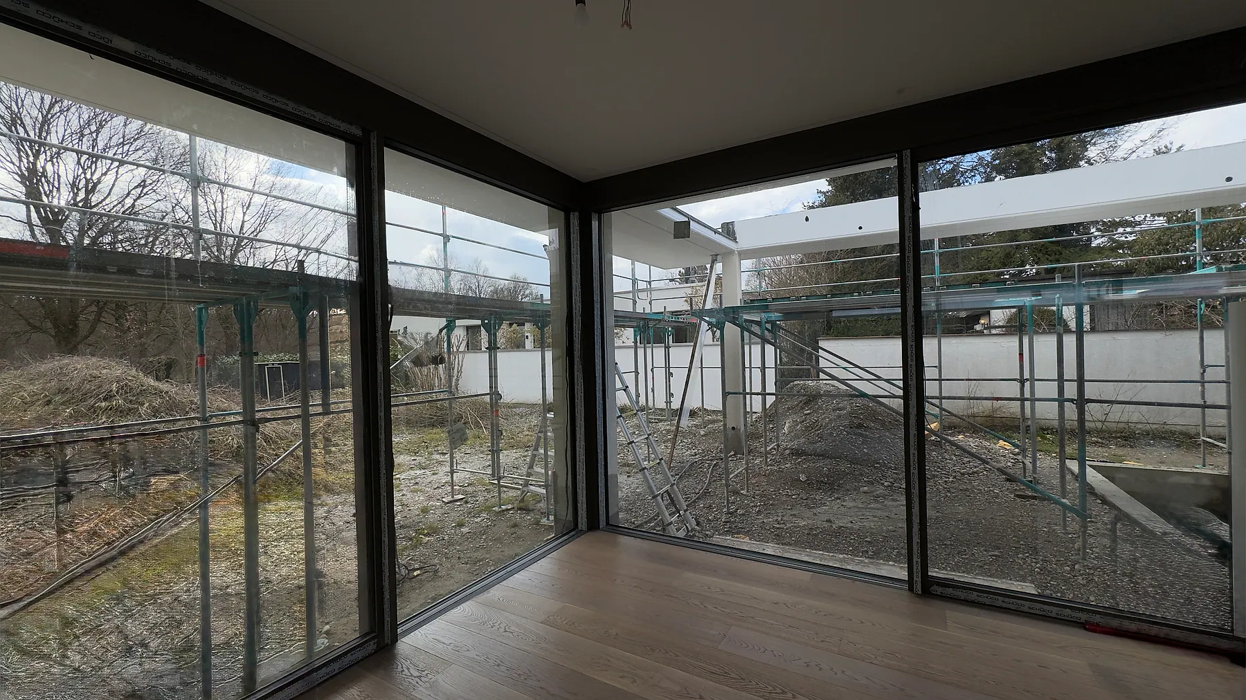 Wohnraum mit großformatiger Aluminium-Eckverglasung während der Bauphase