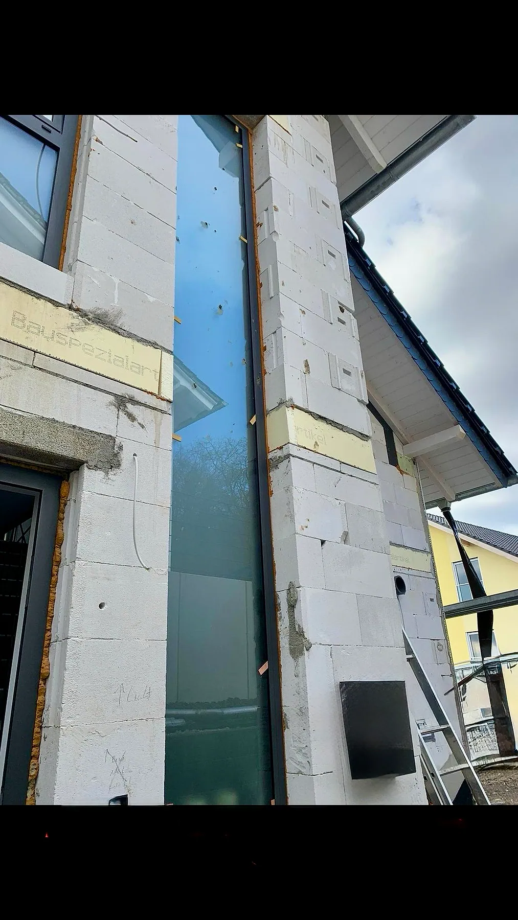 Sehr hohe schmale Festverglasung aus Aluminium in einem Wohnhaus
