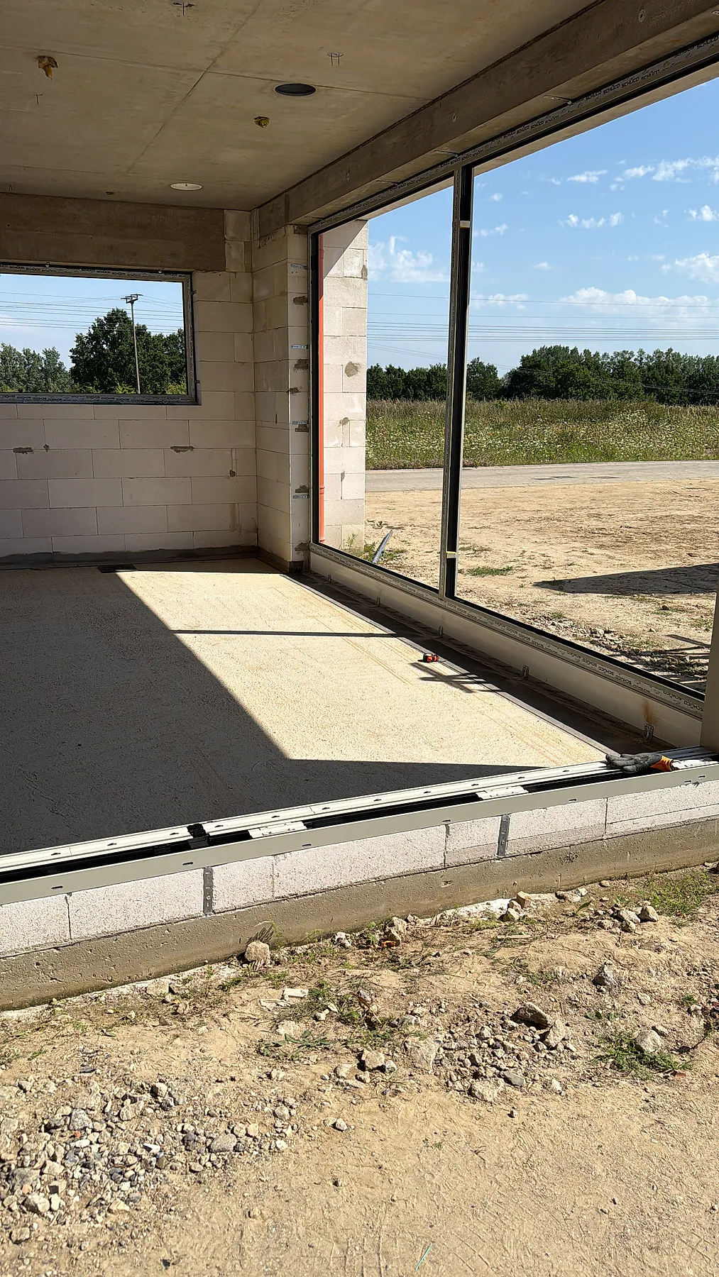 Bodentiefe Aluminium-Schiebetüranlage im Rohbau mit vorbereitetem Bodenanschluss