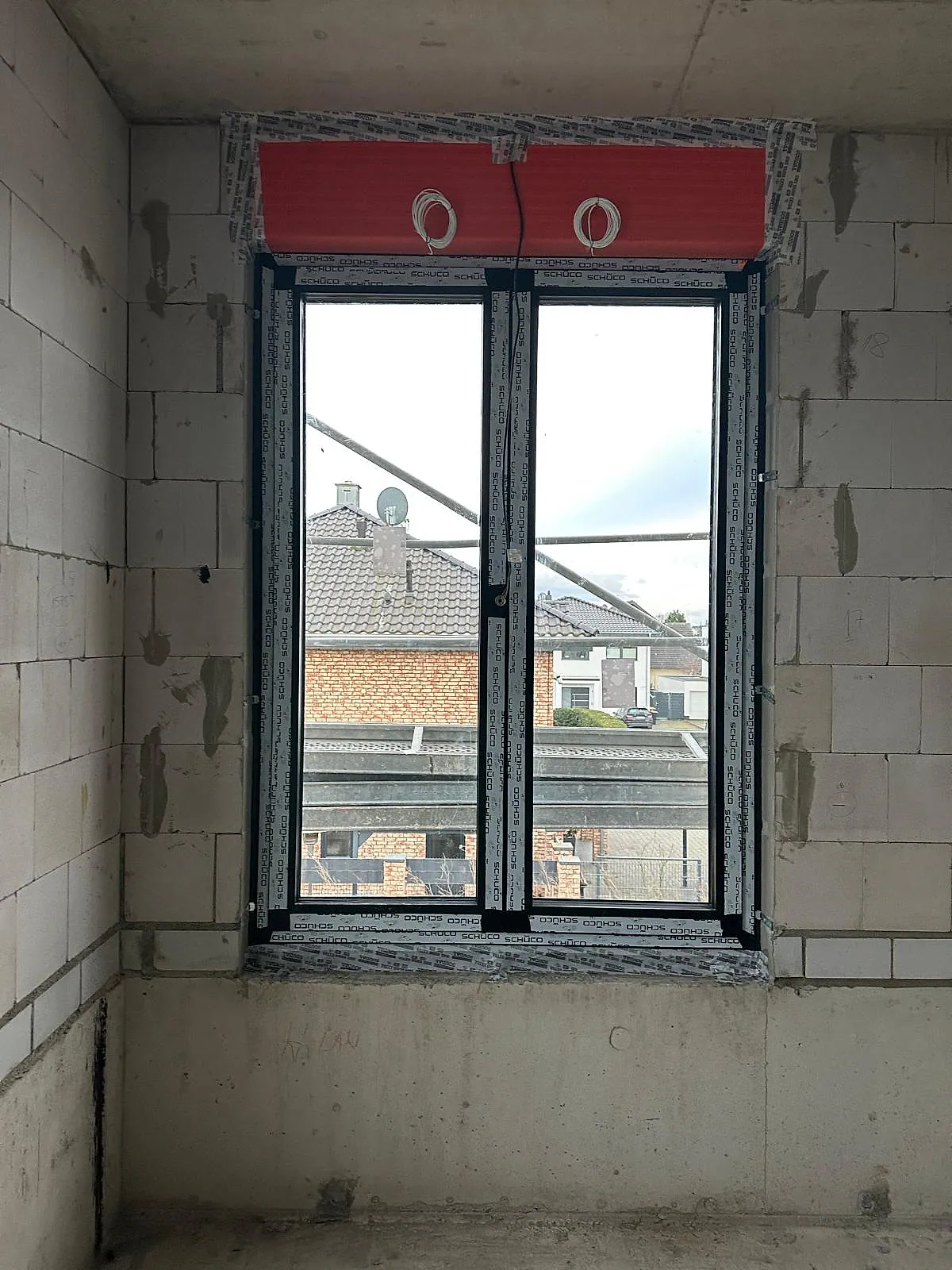 Schmales Aluminiumfenster mit passendem Rollladenkasten in einem Wohnhaus