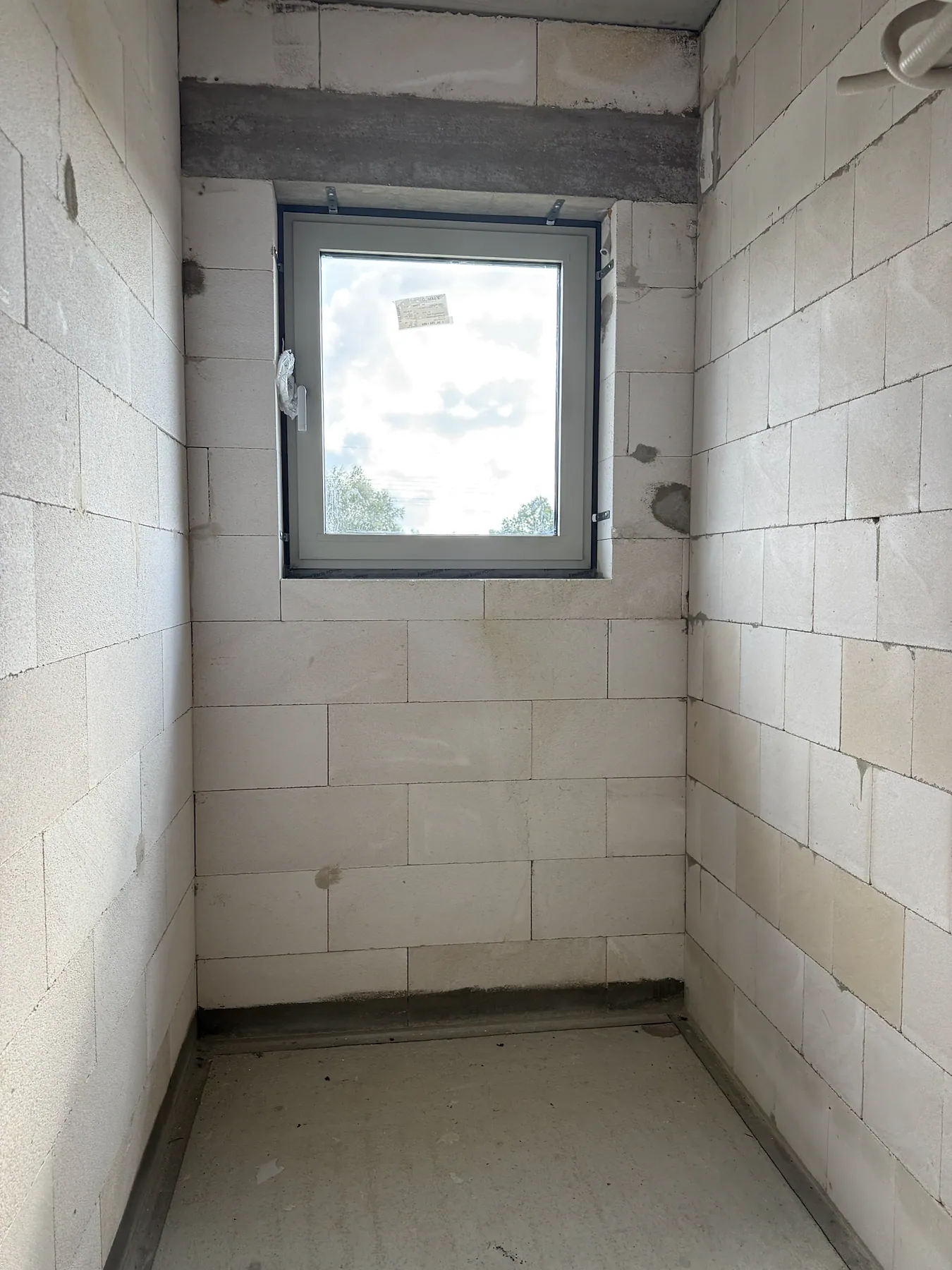 Schmales Aluminiumfenster in einem Treppenraum während der Rohbauphase