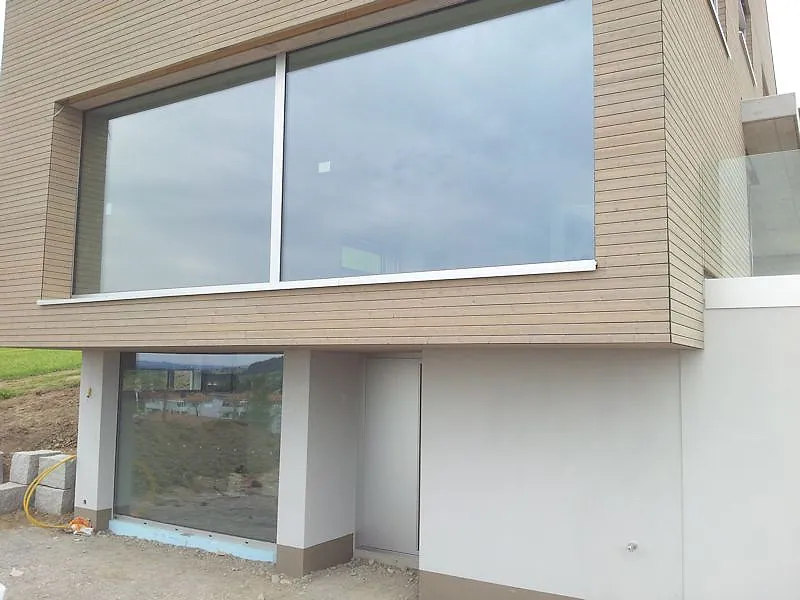 Moderne Villa mit großformatiger Aluminium-Festverglasung in Holzfassade