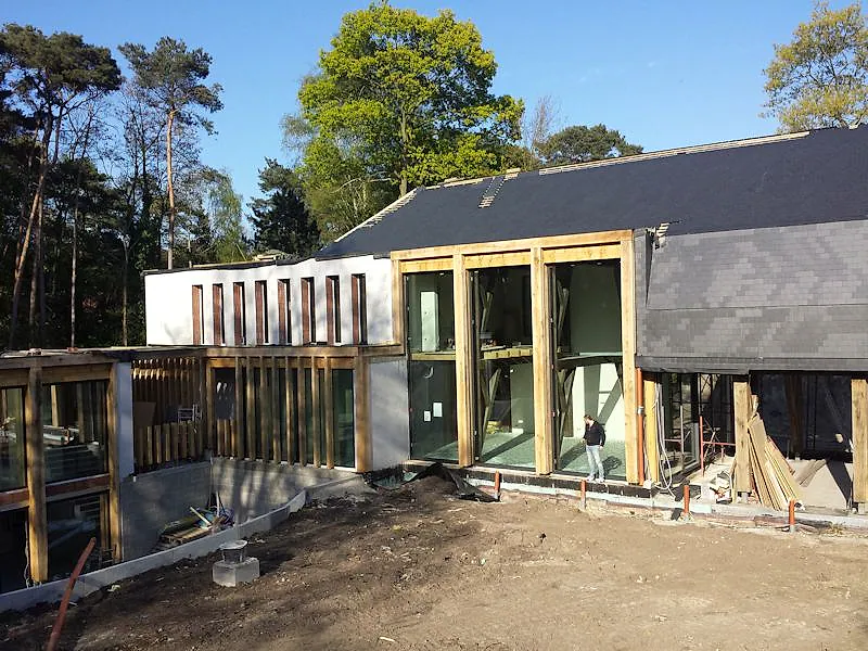 Villa im Rohbau mit hohen schmalen Aluminiumfenstern und großformatigen Glasöffnungen